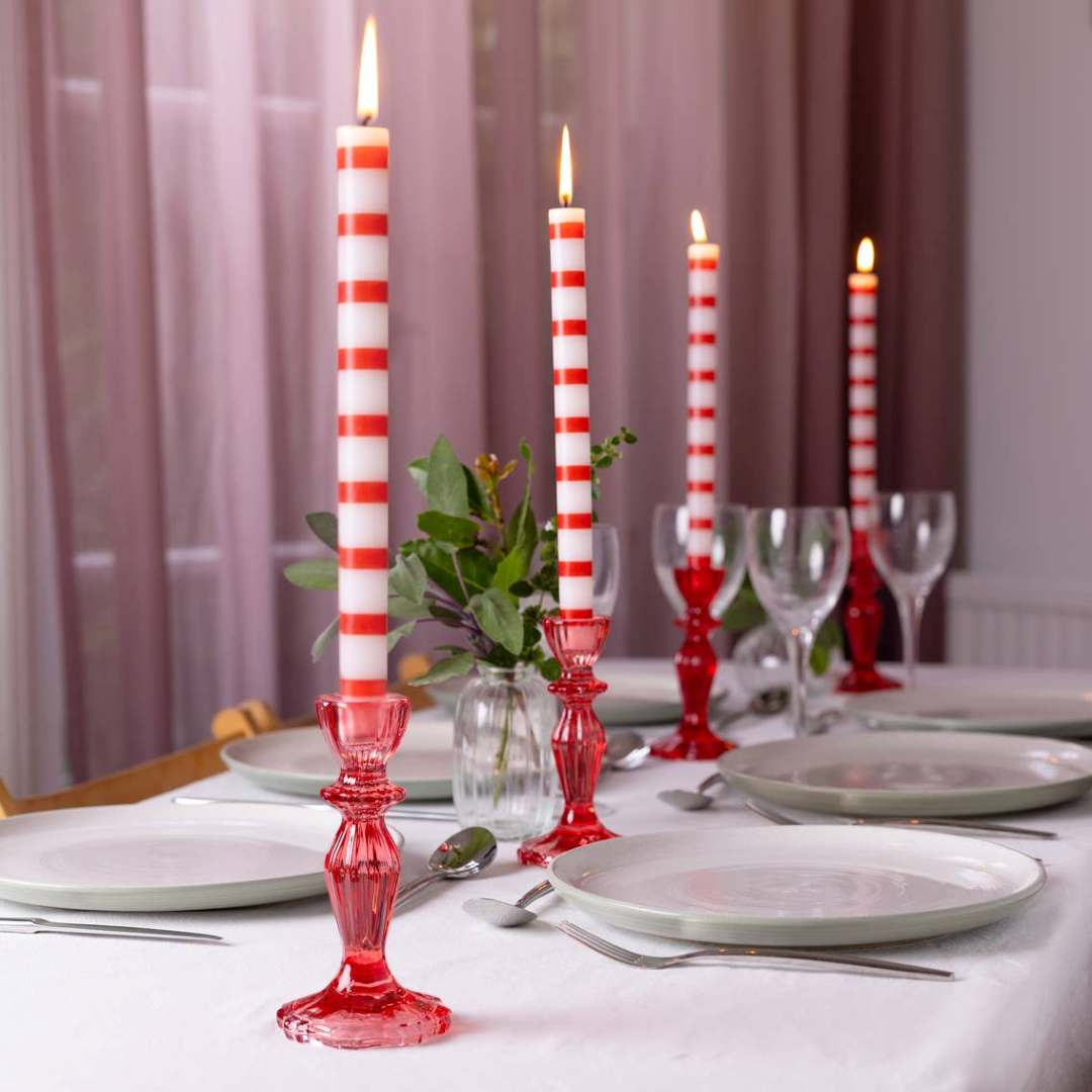 Talking Tables | Dining table setting with red and white striped candles in decorative holders.