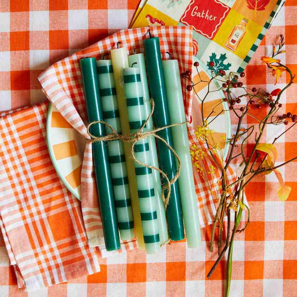 Talking Tables | Set of green candles with striped patterns on a checkered tablecloth