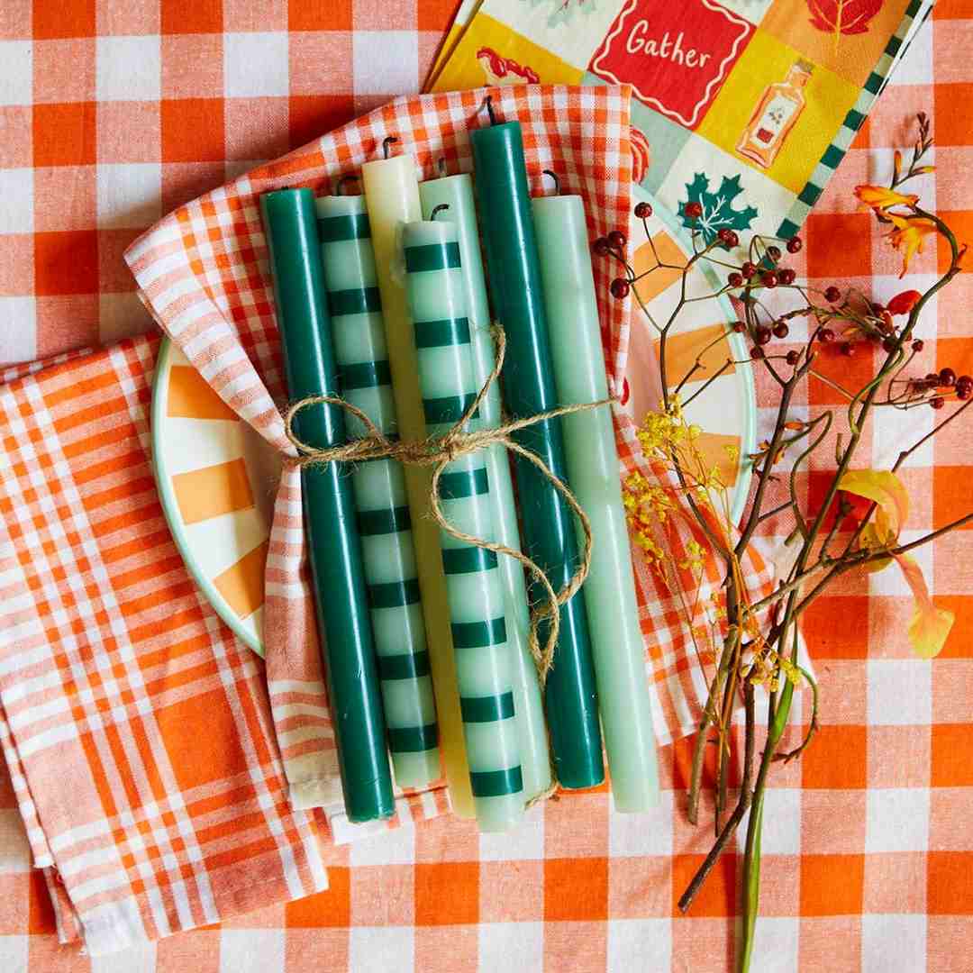 Talking Tables | Set of green candles with striped patterns on a checkered tablecloth