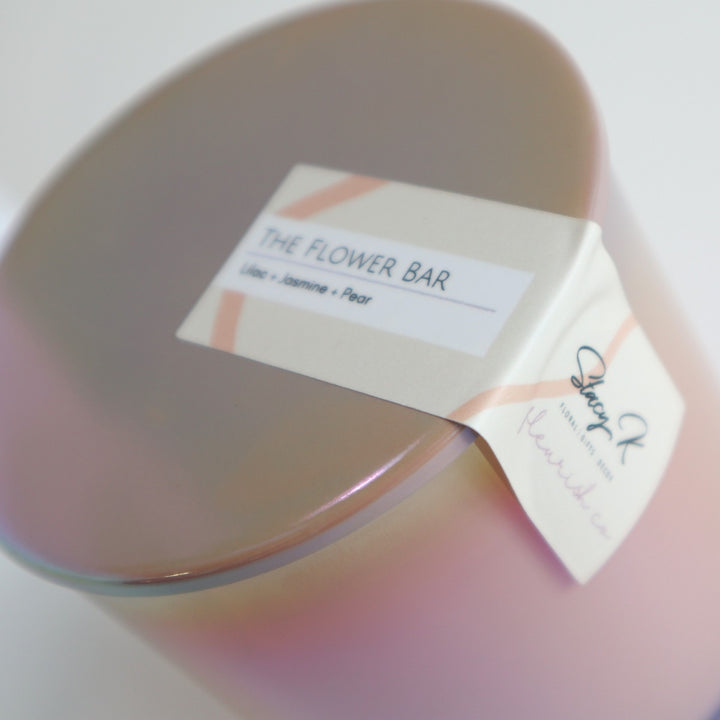 The Flower Bar Candle | A close up on the candle lid and label. The top of the label reads "The Flower Bar, Lilac, Jasmine, Pear",