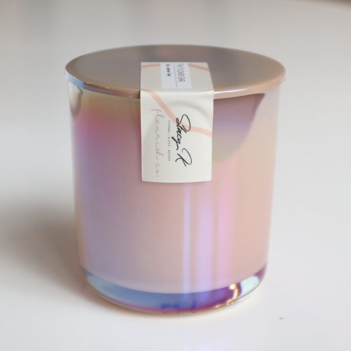 The Flower Bar Candle | An iridescent candle with a simple light yellow label that reads "Stacy K Floral, Floral, Gifts, Decor, Fleurish Co.". 