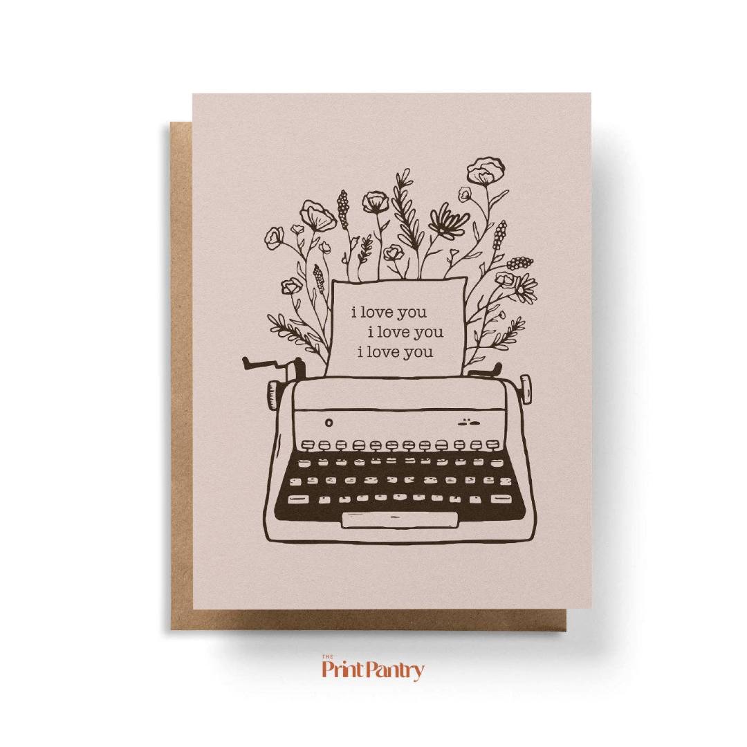 Greeting card with typewriter and floral design on a beige background, featuring the brand 'Print Pantry'.