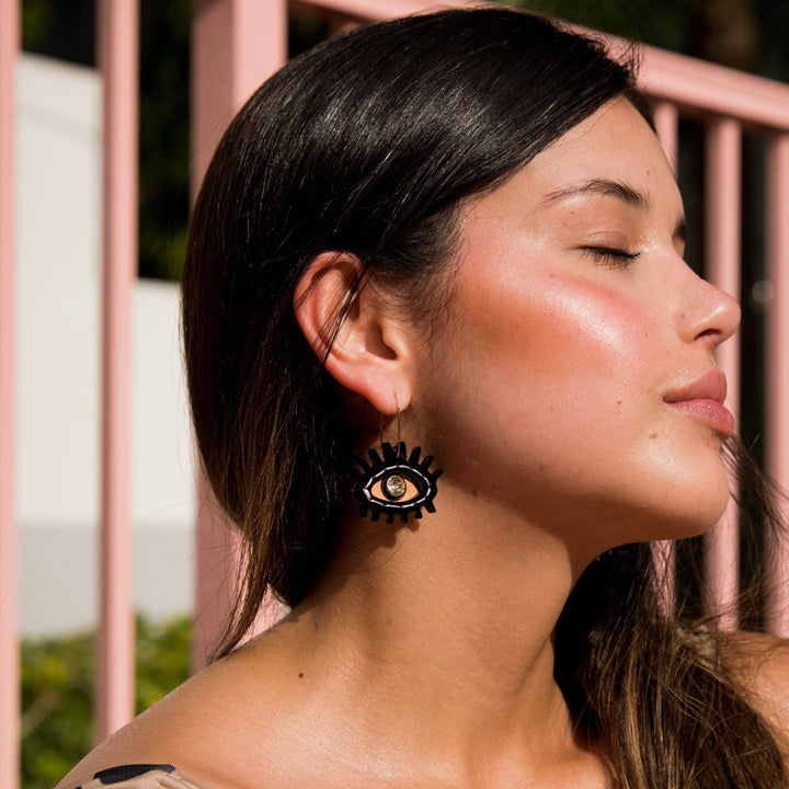 Woman wearing a black floral earring with a blurred background