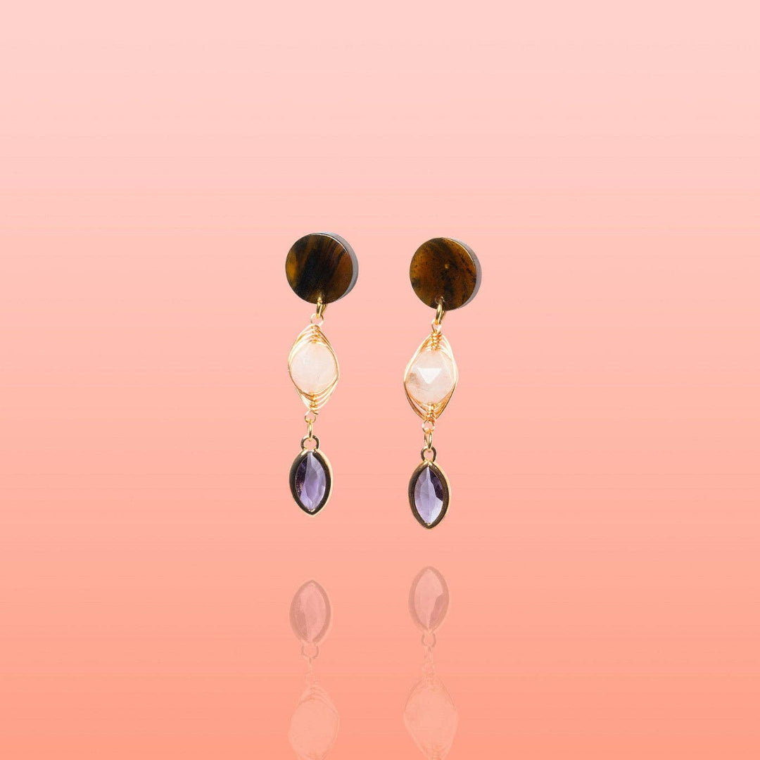 A pair of gold dangle earrings featuring a round brown tiger&