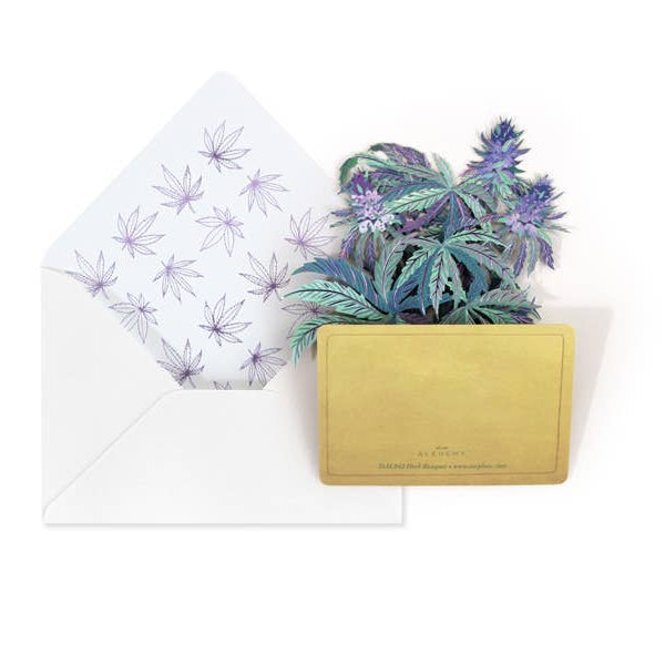 A 3D pop-up card featuring a miniature potted plant with purple and blue marijuana leaves in a gold pot, shown next to an open white envelope with purple marijuana leaf patterns on the liner.