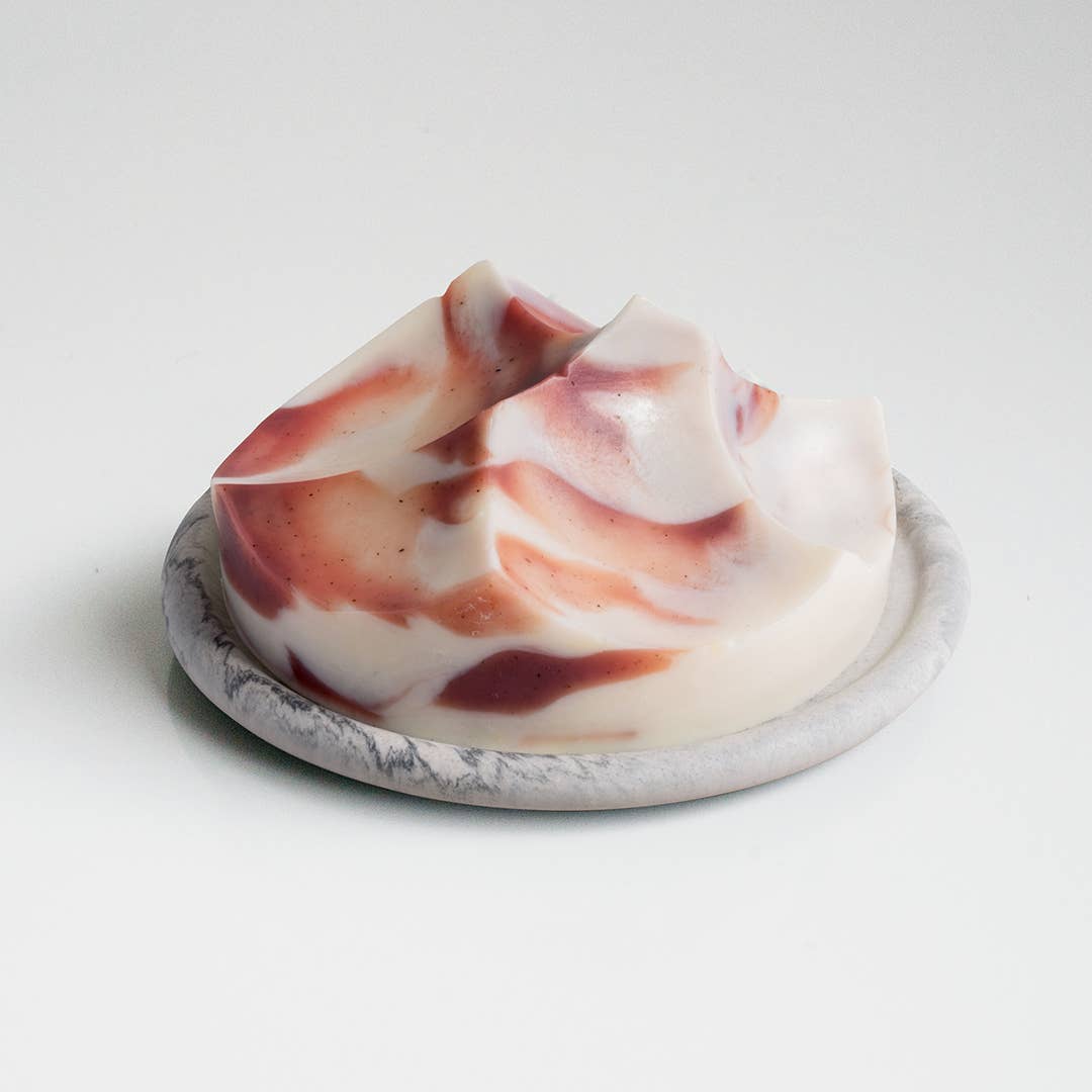 Marbled soap bar on a marble stand with a white background