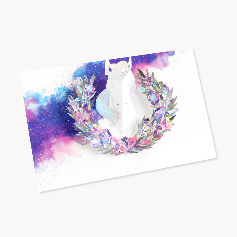 You Are Straight Up Magic | UWP Luxe | A white and galaxy interior with purples/blues/ and pinks. A paper unicorn cut out is white with a shimmering mane and a shimmering colorful crystal illustrated paper pop out wreath.