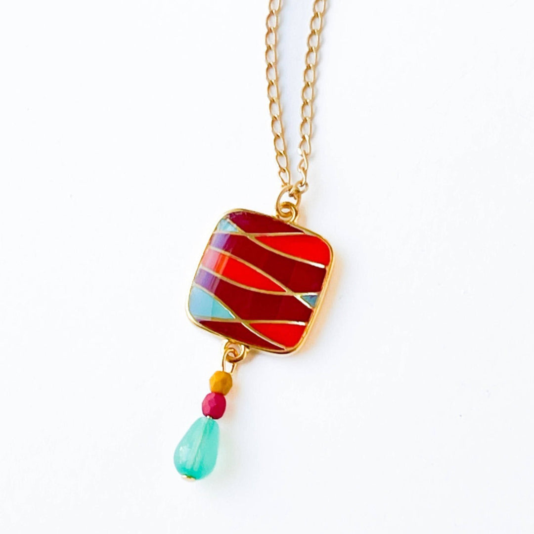 Nest Pretty Things | Mid-Century Pendant Necklace Assorted | Close up on the red/orange/blue striped pendant.