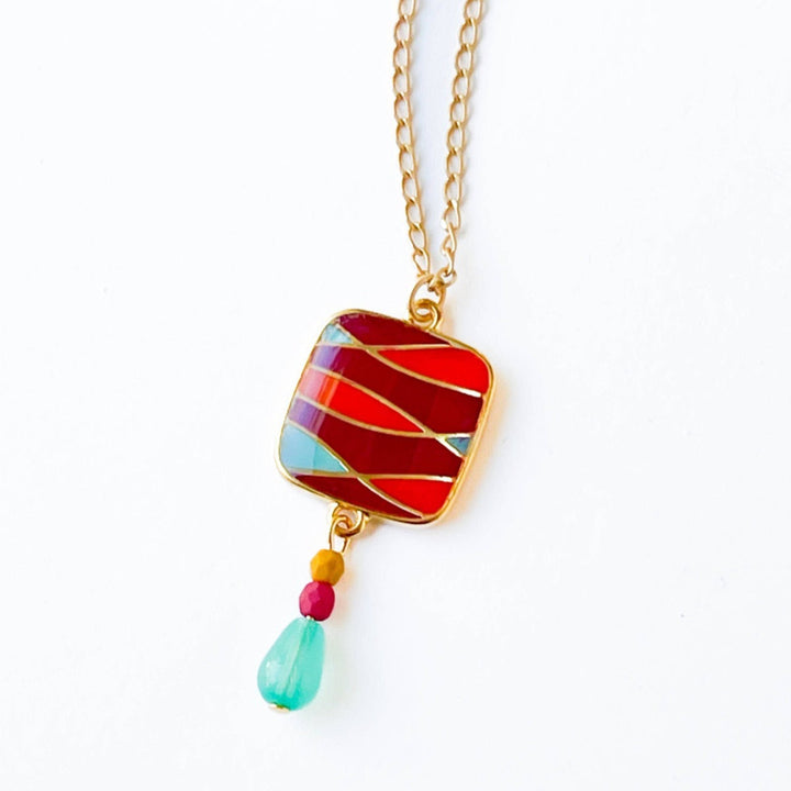 Nest Pretty Things | Mid-Century Pendant Necklace Assorted | Close up on the red/orange/blue striped pendant.