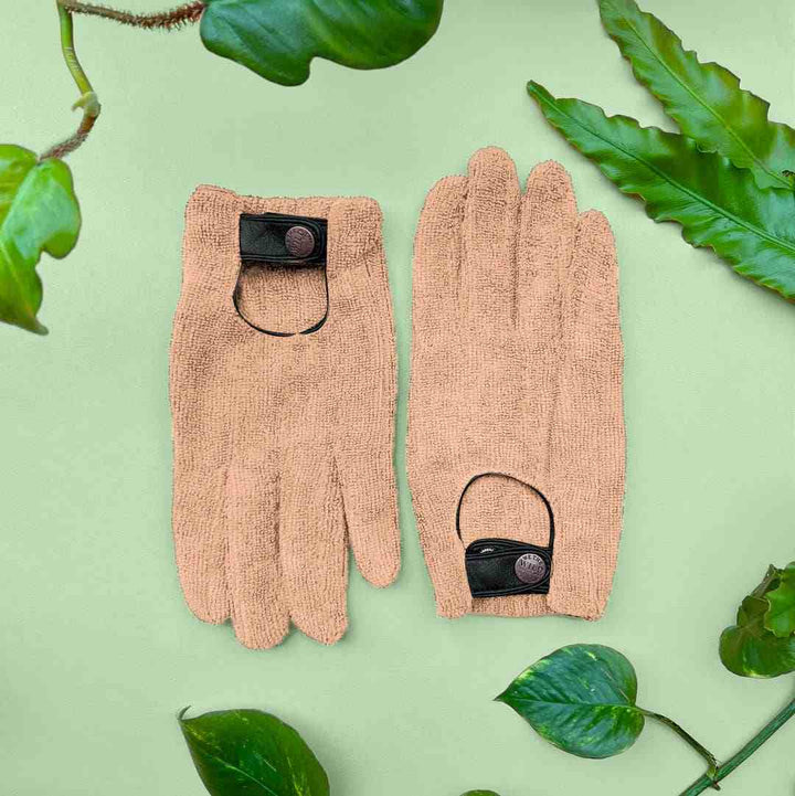 We The Wild | Plant leaf dusting gloves | Pair of beige dusting gloves with black accents on a green background with leaves.
