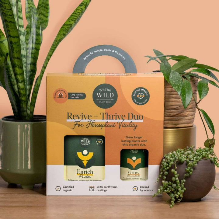 Revive and Thrive Duo Kit | We the Wild | An orange box with a bag of enrich powder and a bottle of grow concentrate. Photo taken against houseplants in pots.