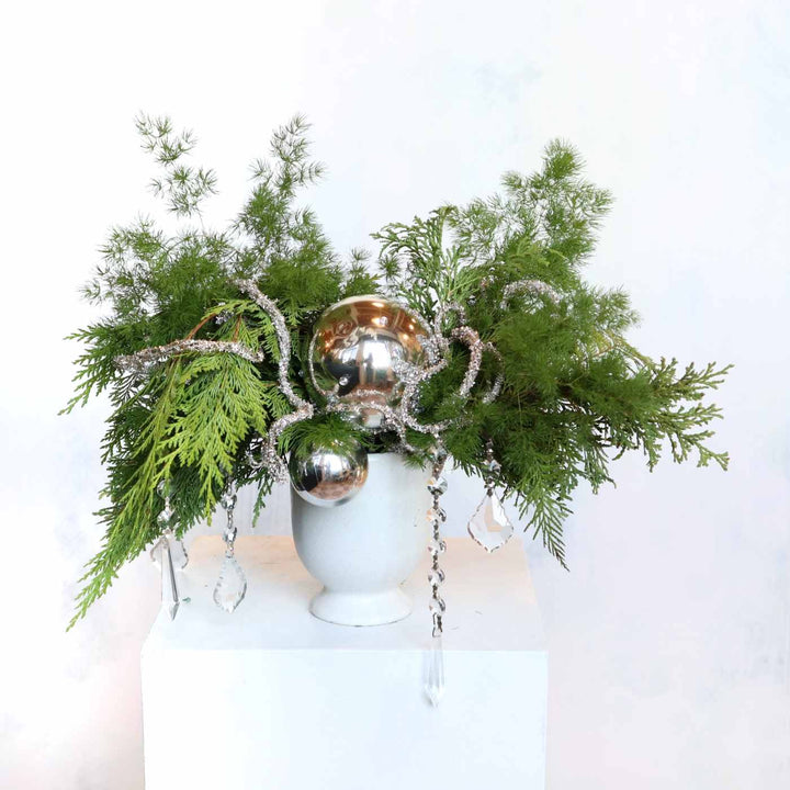 Winter's Glow | A wintergreens arrangement with sparkling branching, ornaments, and crystals.