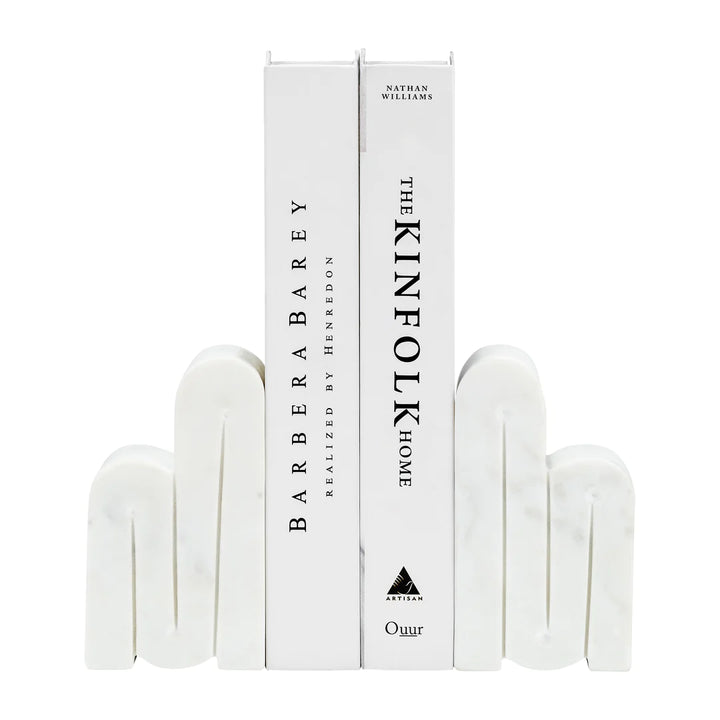 Swirly Marble Bookends | White marble bookends in a swirling pattern, holding up two books: BarberaBarey Realized by Henredon, and The Kinfolk Home by Nathan Williams".