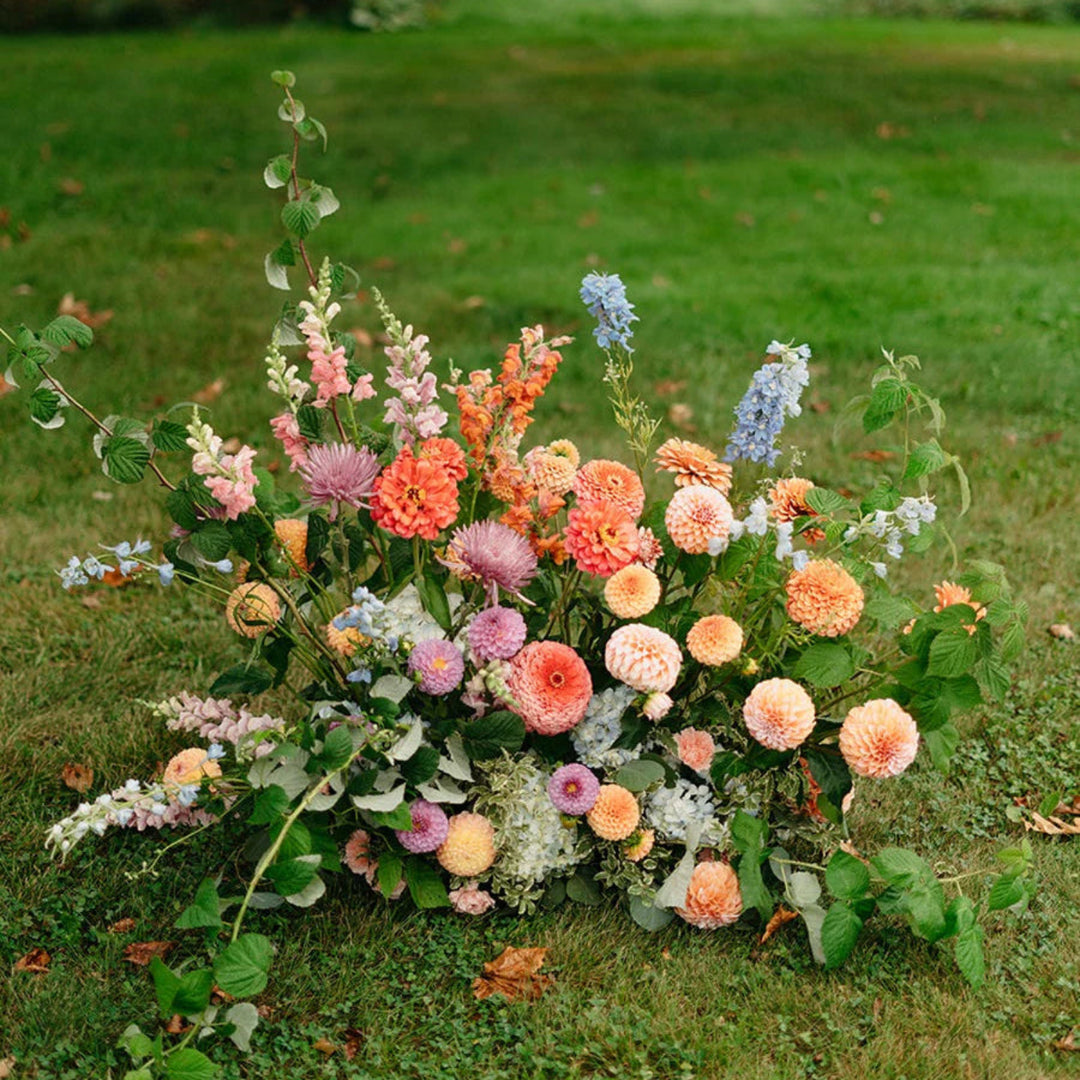 Stacy K Floral | Floor arrangement with a variety of flowers. Some shown are dahlias, snapdragons, hydrangea, and greenery.