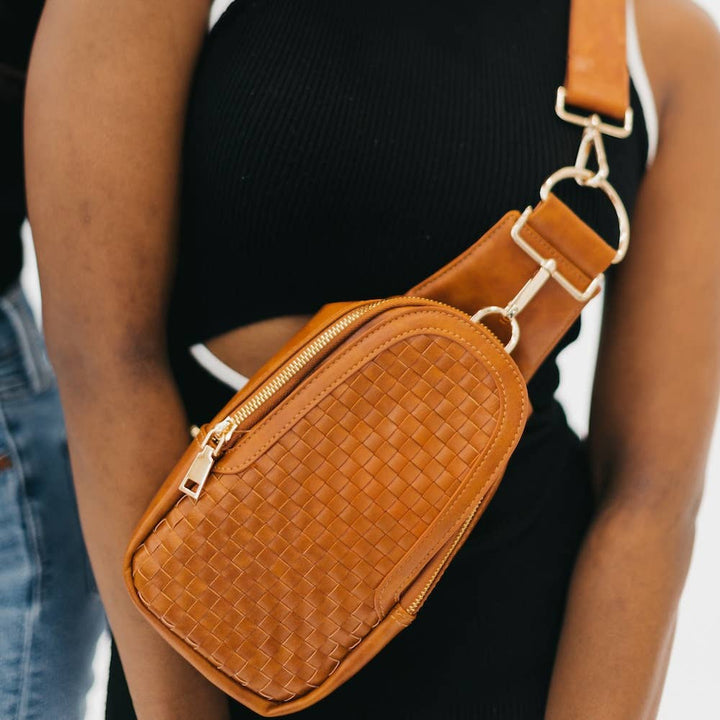 Close up on the woven vegan leather crossbody bag with gold hardware.