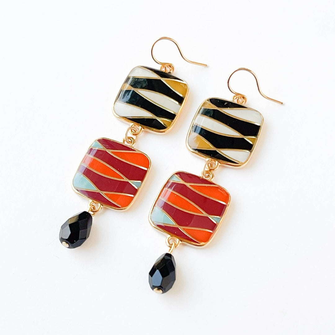 Nest Pretty Things | Long Statement Retro Dangle Earrings | Close up on the black, yellow, white, pink, orange, and blue earrings with gold accents.