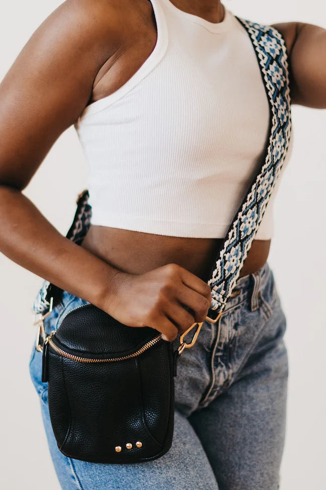 Ellie Crossbody Bag in black. This Faux-leather crossbody bag is so soft and dreamy. Comes with a trendy and fun canvas strap and shiny gold classic hardware! The size is small enough that you'll forget you're wearing it but big enough to fit your phone, keys, and wallet!