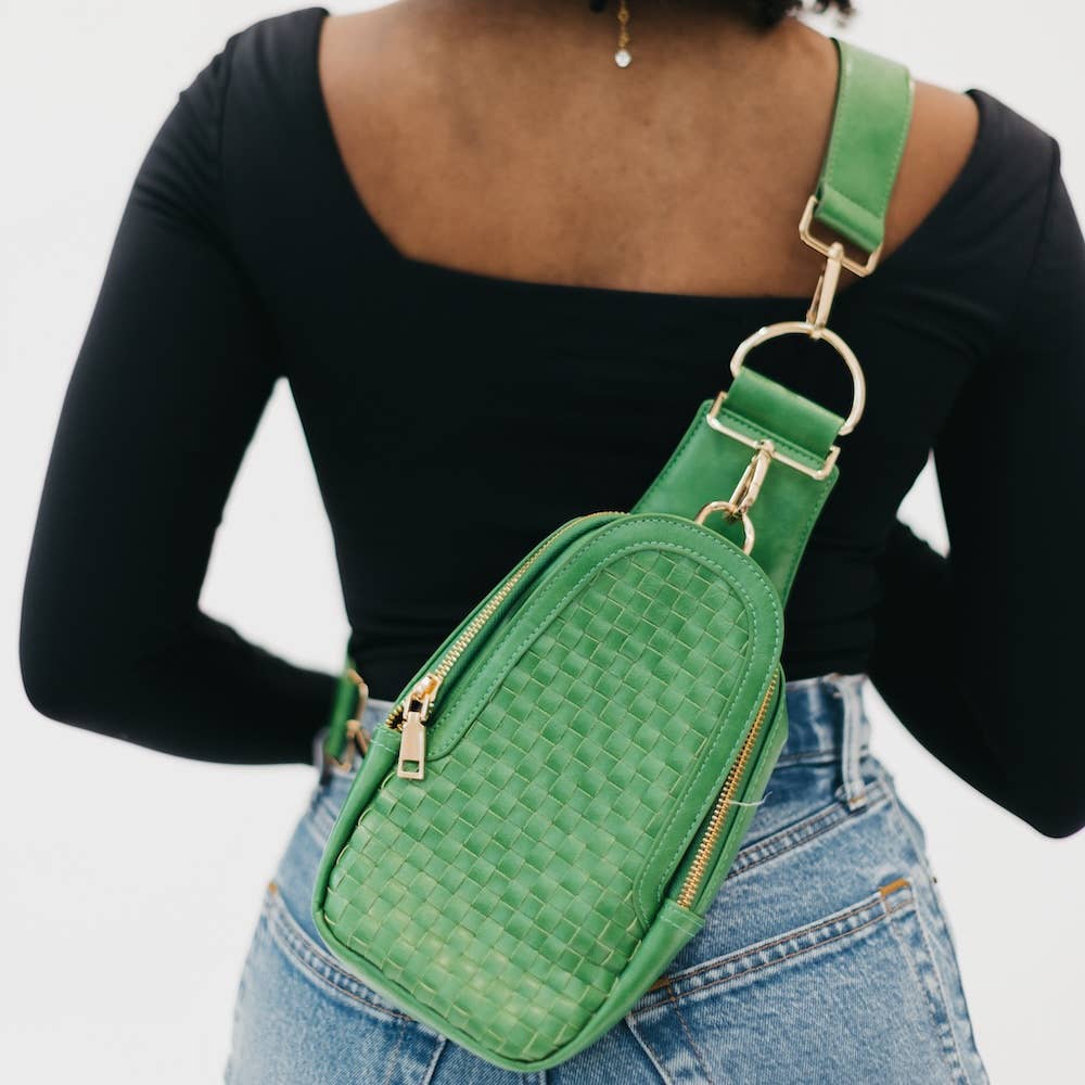 A green crossbody bag with a woven texture and gold hardware. Made with vegan leather.