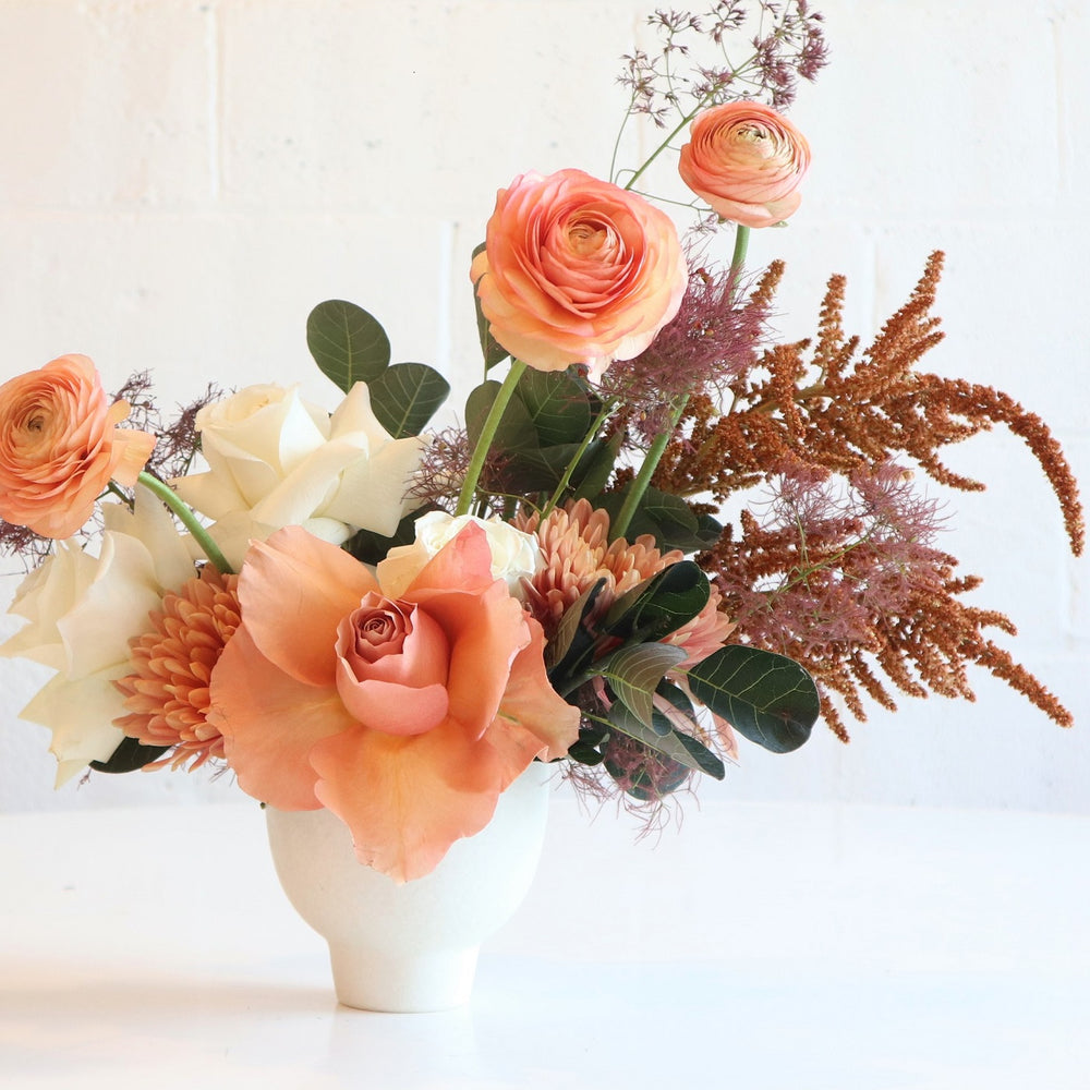 Orange Creamsicle | Stacy K Floral | Fresh Floral Arrangement | Close up shot of roses and ranunculus. Photo taken against a white background.