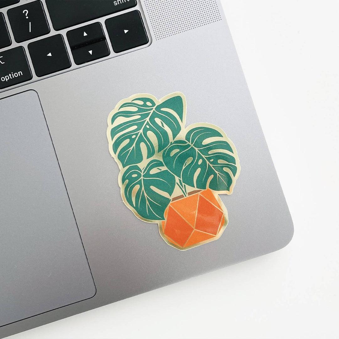 Paper Anchor Co. Monstera Sticker | A monster plant sticker in  an orange pot with gold accents.