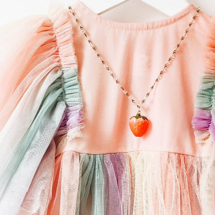 Nest Pretty Things | Kids Strawberry Charm Necklace | Close up on the necklace on childs clothing for scale reference.