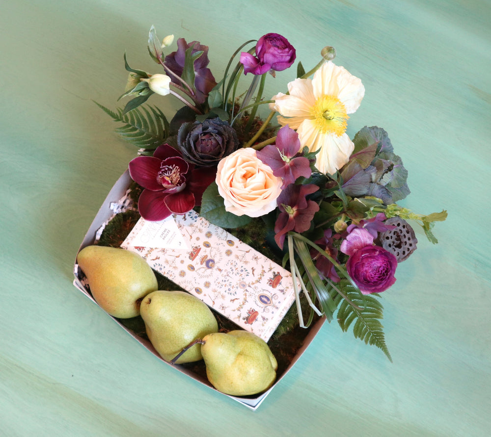 Fruit box with three pears, Compartes chocolate and a floral arrangement with helleborus, poppies, kale, orchis, ranunculus. 