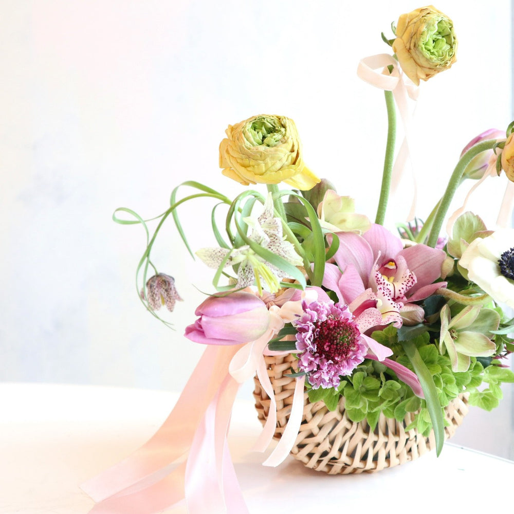 Petals & Charm Basket | Close up on the tulips and other florals. Fresh floral arrangement made in a woven basket.