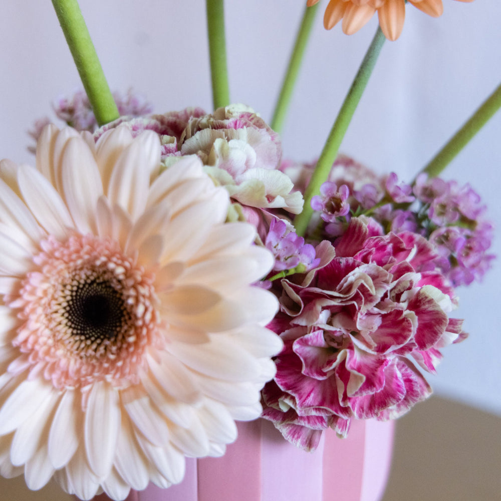 Close-up of a bouquet of flowers with a pink vase