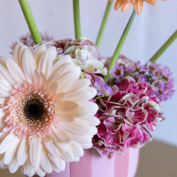 Close-up of a bouquet of flowers with a pink vase