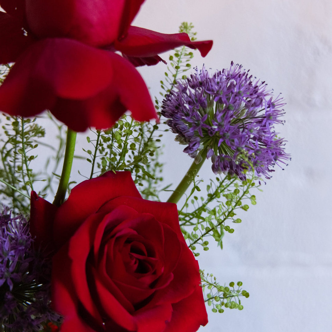Close-up of red roses and purple flowers