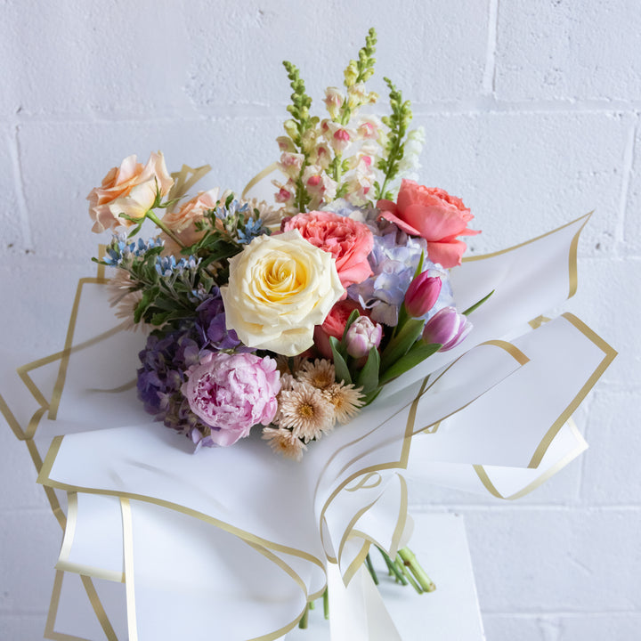 Bouquet of colorful flowers on a white surface with geometric gold designs