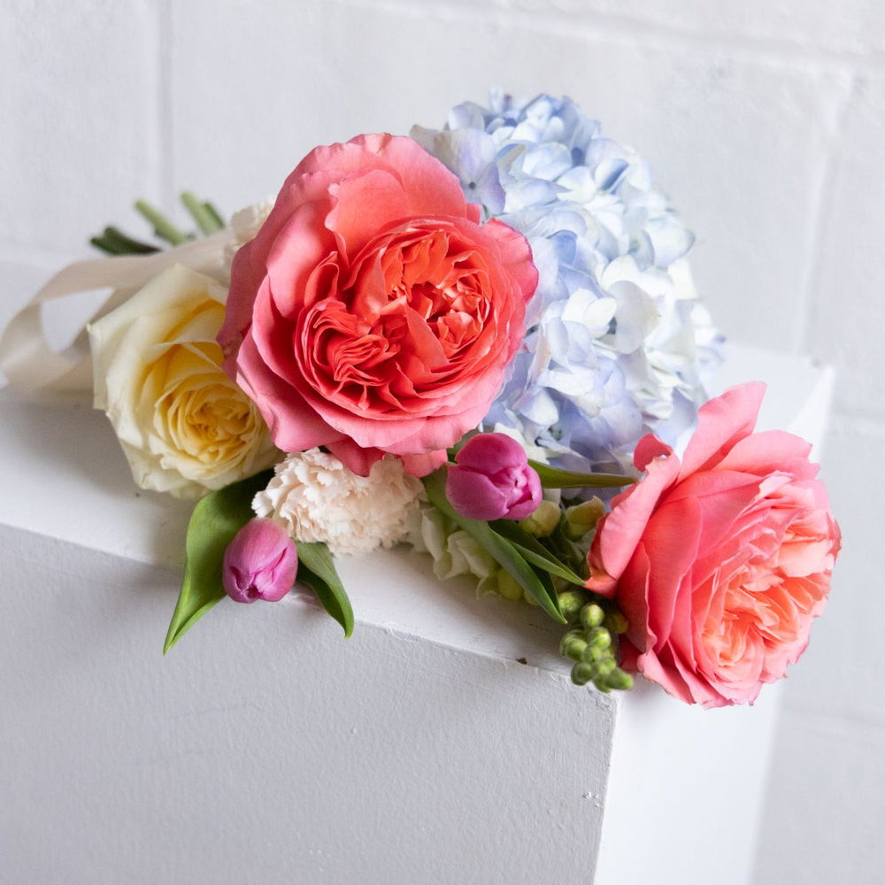 Floral arrangement with pink, yellow, and white flowers on a white background