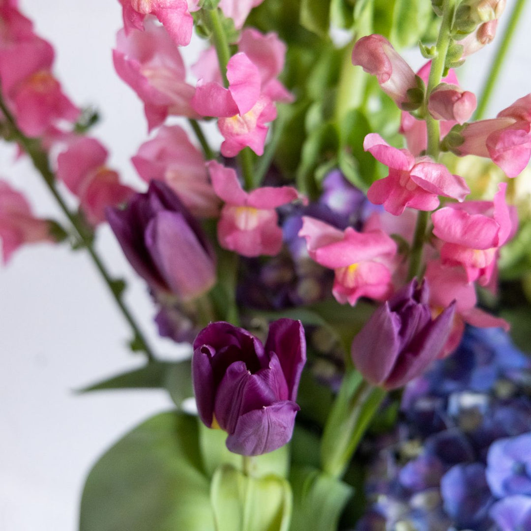 Bouquet of pink, purple, and green flowers with a blurred background