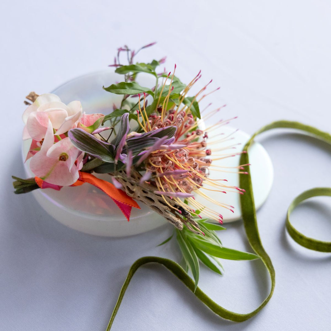 boutonniere with a green ribbon on a light background