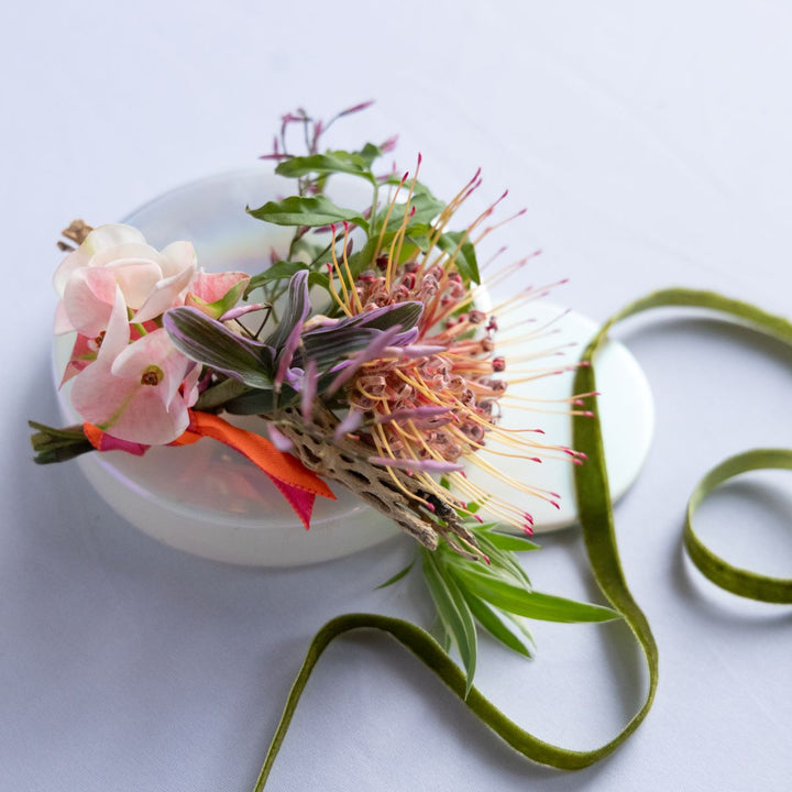 boutonniere with a green ribbon on a light background