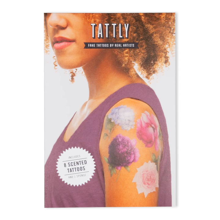Tattly Tattoos | Photo shows the packaging with the flowers on the shoulder of the model, reads "tattly, fake tattoos by real artists, includes 8 scented tattoos, and 1 sponge.".
