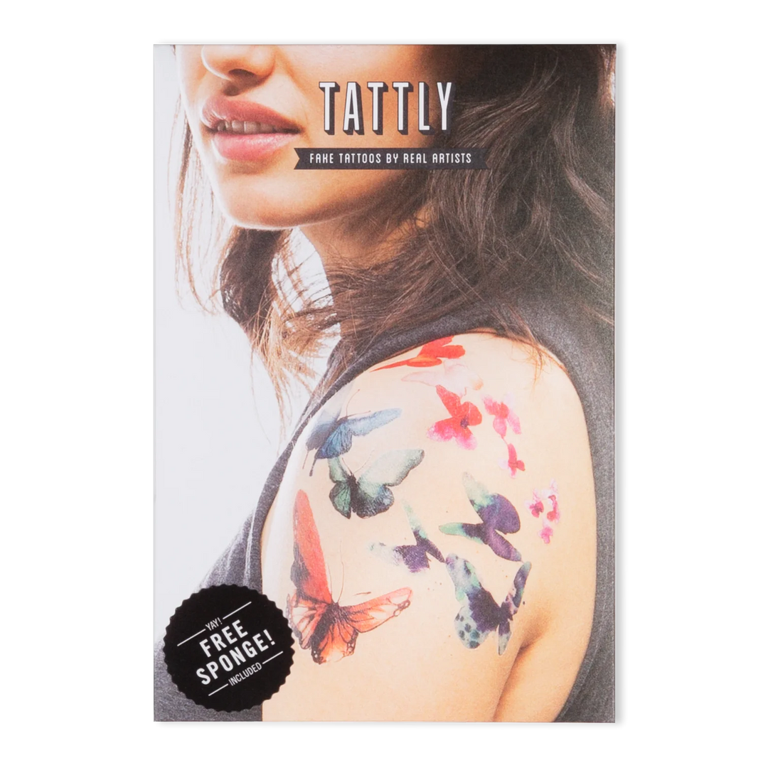 Tattly Tattoos | A photo of the tattoo package, shows watercolor butterfly tattoos on the models shoulder. Cover reads " Tattly, fake tattoos by real artists, yay, free sponge!, included.".