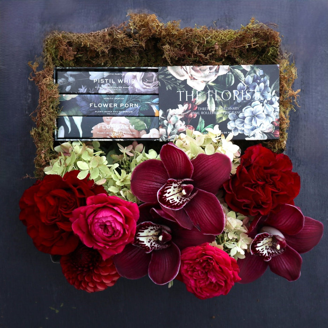 The Florist Gift Box | Stacy K Floral | A luxory gift box decorated with moss and filled with a red and green floral arrangement (featuring roses, hydrangea, orchids, and dahlias), and florist themed perfumes.