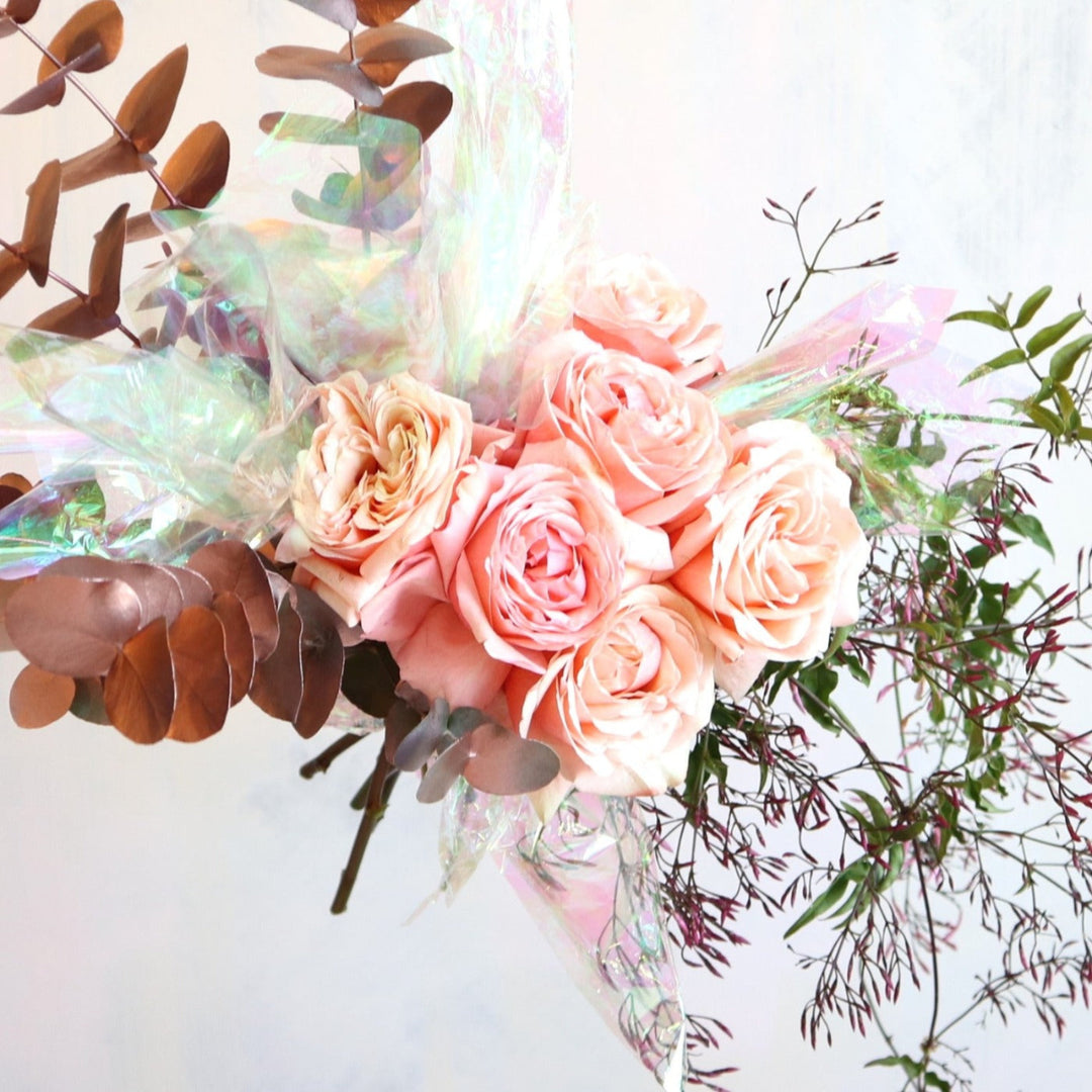 Half dozen peach roses with jasmine vine, rose gold eucalyptus and iridescent paper 