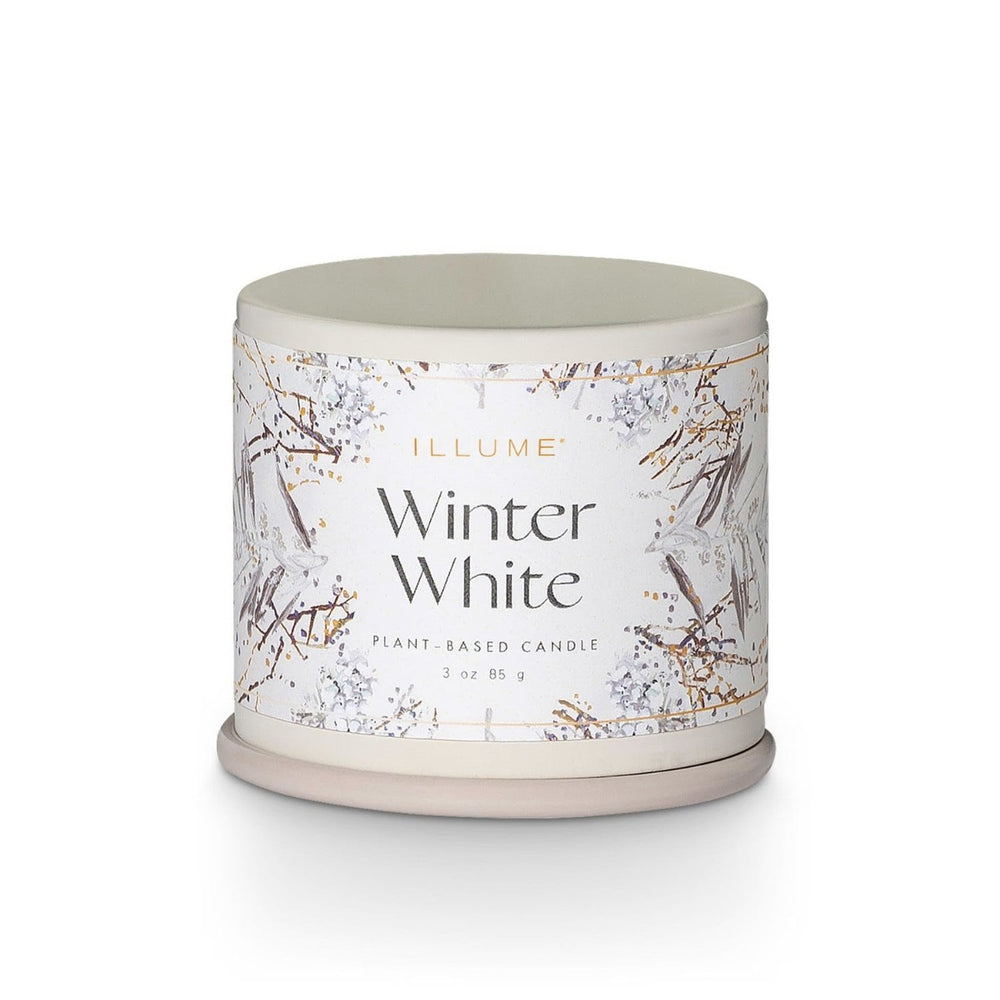 Illume Demi Tin Candle | Winter White | A white tin candle with a label decorated with branches in a winter scene. Label reads "Illume winter white, plant based candle 3oz, 85g."