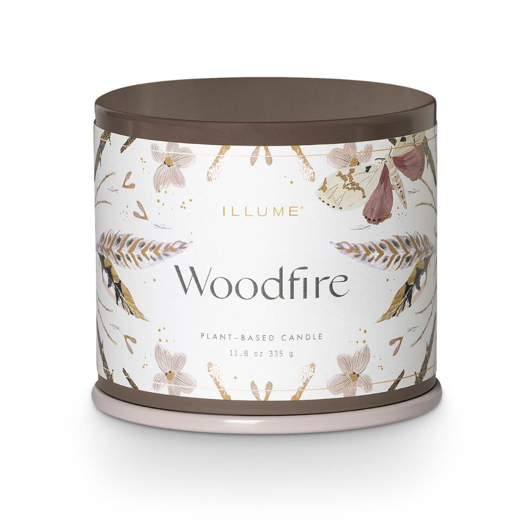 Illume Woodfire Candle | Woodfire | A white candle with illustrated feathers, moths, a seeds. Label reads "Illume, woodfire, plant based candle, 11.8 oz, 335 g."