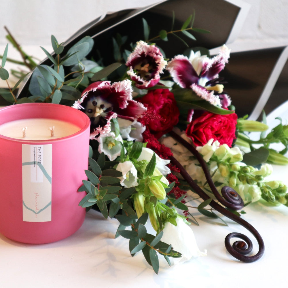 Fleurish and Flowers | This Set includes a scented " PORT" pinkFleurish Candle and a wrapped bouquet including purple tulips, dark pink roses, white snap dragons, white campanula, curly fern and parvafolia eucalyptus 