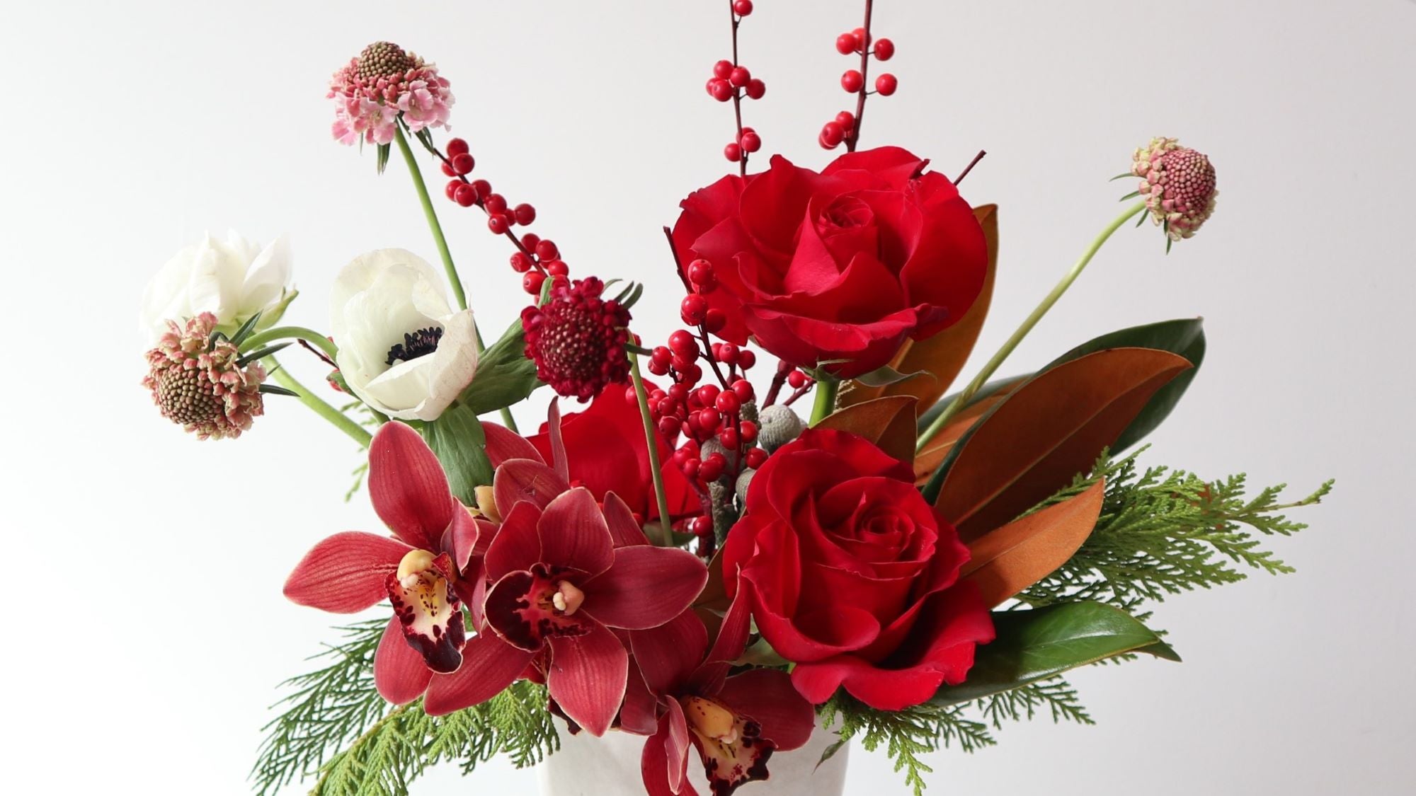 red holiday image with wintergreens roses and orchids