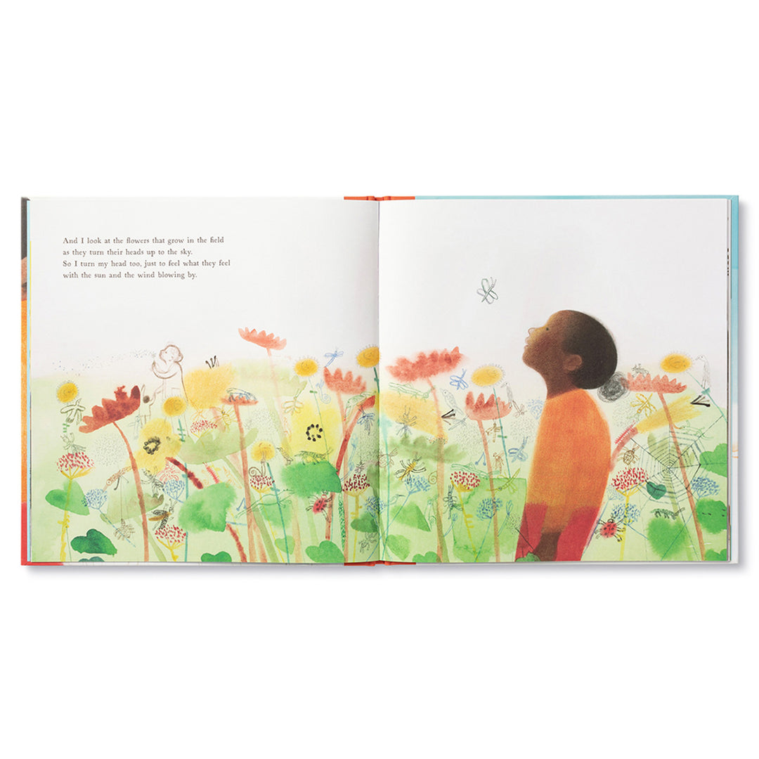 All That I Am | Open book spread with illustration showing a child looking up at the sky with drawings of plants and bugs all around. The text on this page reads "And I look at the flowers that grow in the field as they turn their heads up to the sky. So I turn my head too, just to feel what they feel with the sun and the wind blowing by.".