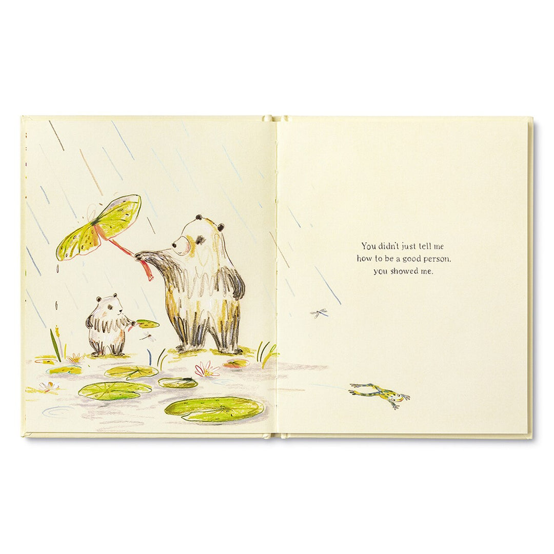 Because of You, Dad | Open book spread, father panda holding a lily pad over his child protecting him from the rain. The child panda is holding a smaller lily pad over a dragonfly to protect it from the rain as well. The text on the page reads "You didn't just tell me how to be a good person, you showed me.".