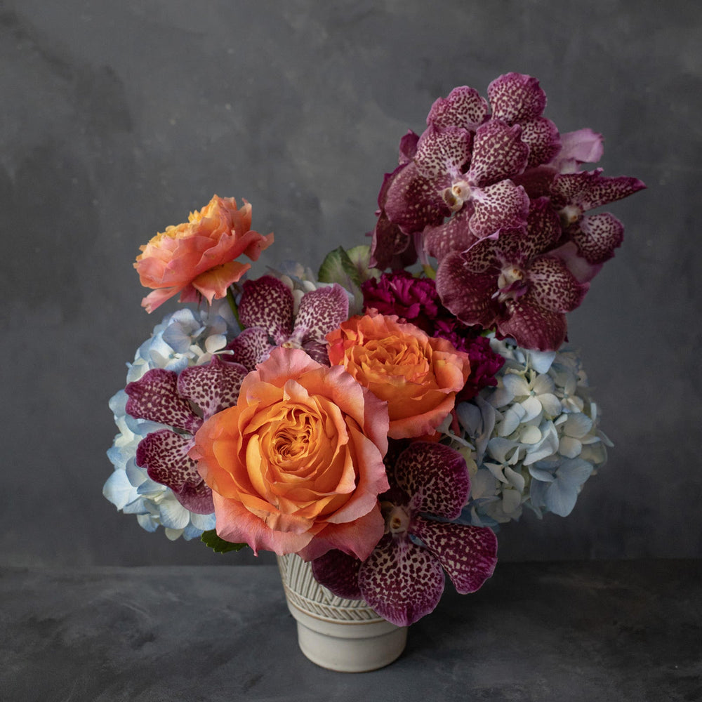 Bright and Beautiful | Colorful floral arrangement with orchids and roses against a grey backdrop | Stacy K Floral Rochester NY