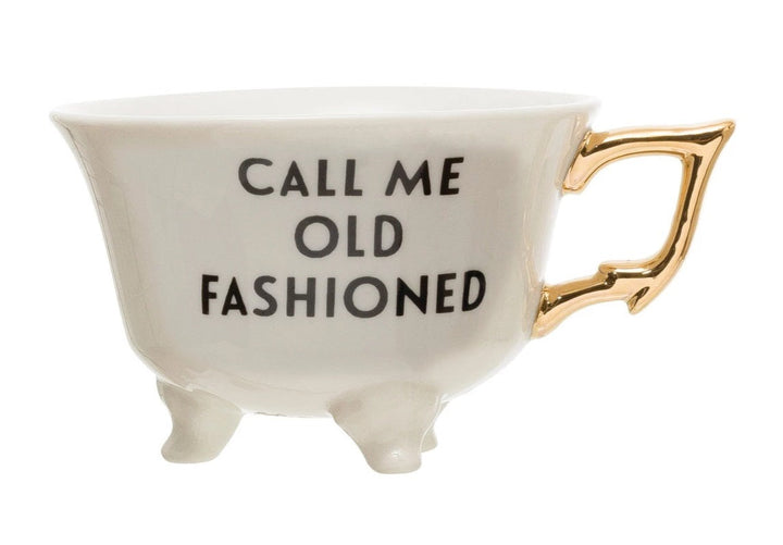 Saying Teacups | White Teacup with little feet and a gold handle. Reads "Call Me Old Fashioned".