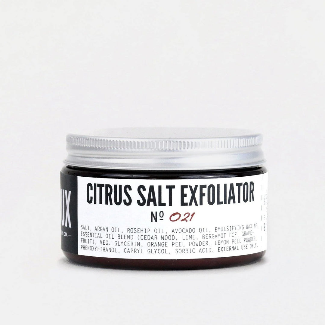 Crux Citrus Salt Exfoliator No 021 | Salt, Argan oil, rosehip oil, avocado oil, emulsifying wax nf, essential oil blend (cedar wood, lime, bergamot fcf, grapefruit), veg. glycerin, orange peel powder, lemon peel powder, phenoxyethanol, capryl glycol, sorbic acid. External use only. A container with simple black and white packaging.