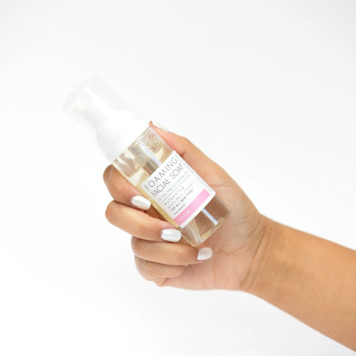 Foaming Facial Soap | Honey Belle | Hand holding foaming facial soap bottle, 1.6oz/50 ml, Rose.