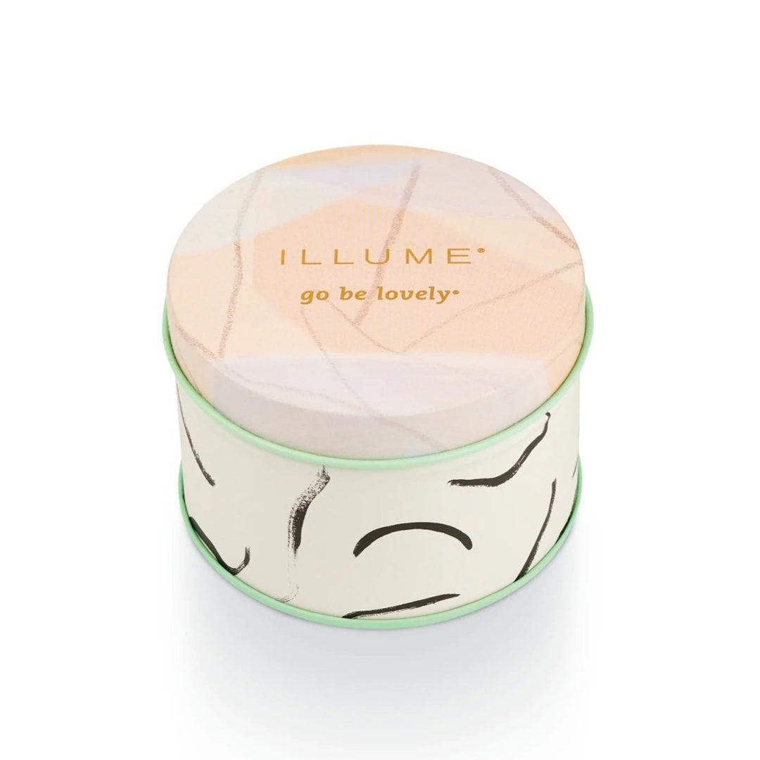 Illume Coconut Milk Mango Fleur Tin Candle. Pink pastels and mint green tin. Top reads "Illume Go be lovely".